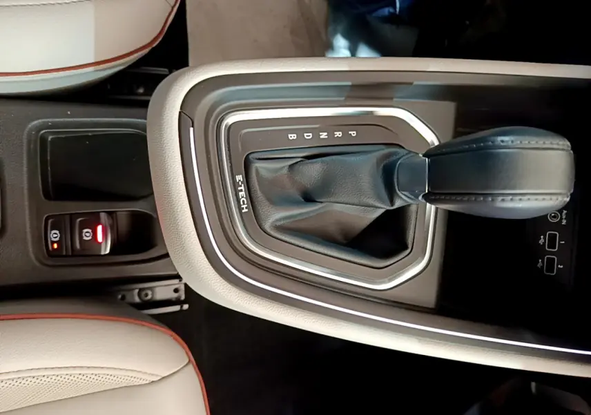 Gros plan sur la console centrale beige avec levier de vitesse automatique noir marqué E-TECH dans une Renault Clio Initiale Paris.