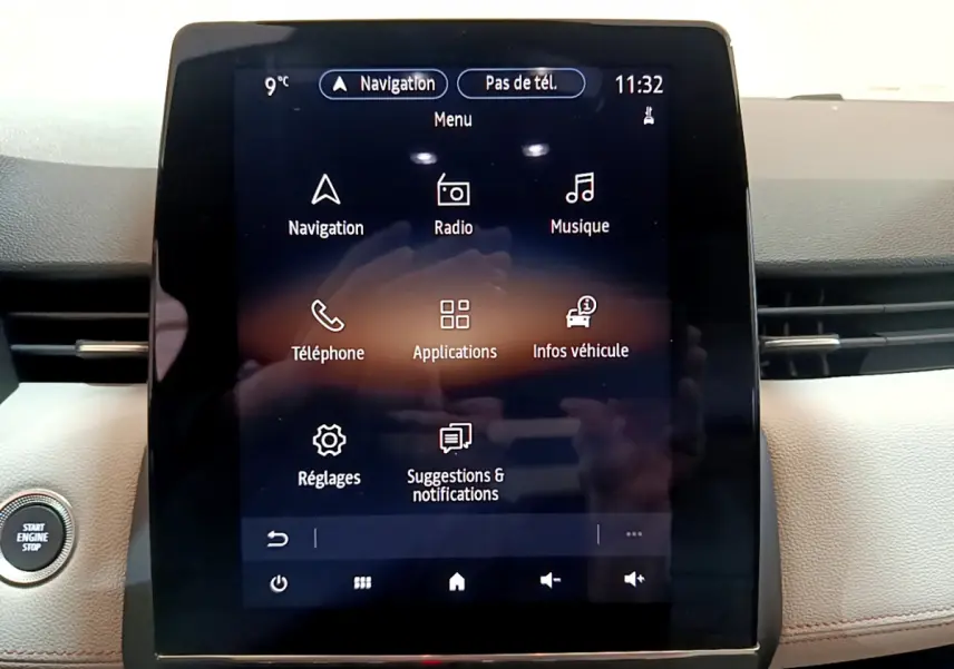 Écran tactile central de la Renault Clio Initiale Paris orange 2021 affichant le menu multimédia avec bouton démarrage visible à gauche
