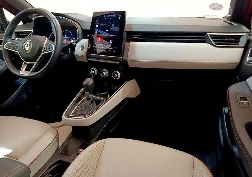 Intérieur de la Renault Clio Initiale Paris E-TECH 140, vue côté conducteur, tableau de bord beige et noir avec écran tactile vertical.