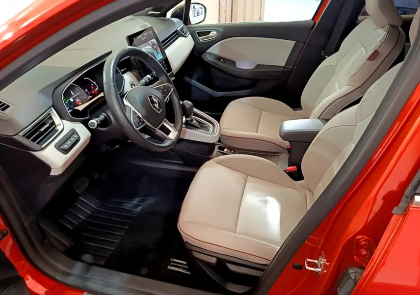 Intérieur avant droit de la Renault Clio Initiale Paris orange 2021 avec sièges cuir beige et écran tactile vertical.