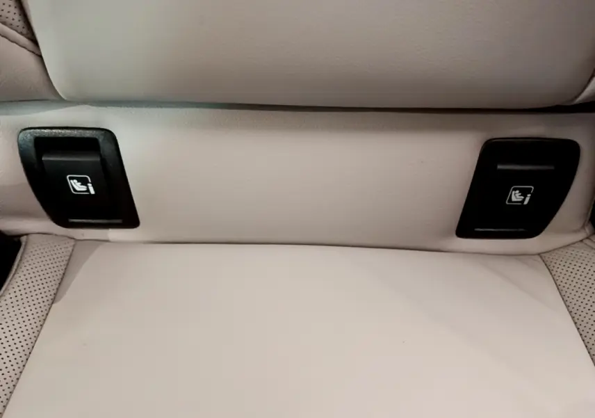 Détail des commandes Isofix noires sur siège arrière en cuir beige clair de Renault Clio Initiale Paris 2021.