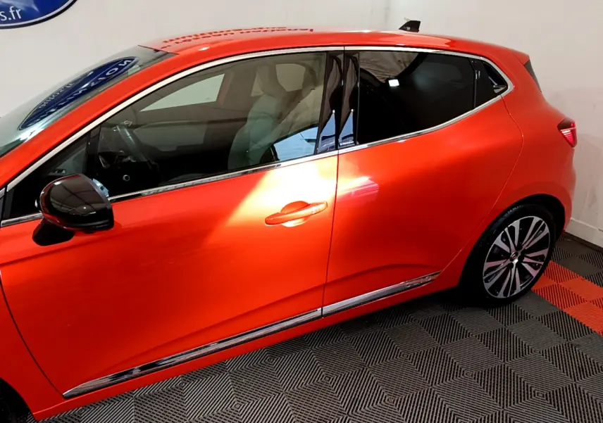 Profil côté gauche de la Renault Clio Initiale Paris orange 2021 avec jantes alliage et rétroviseur noir brillant