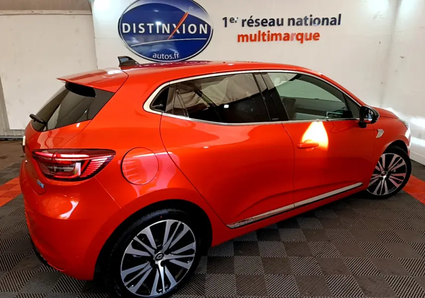 Renault Clio Initiale Paris E-TECH 140 orange vue de profil côté droit, avec jantes alliage et vitres teintées.