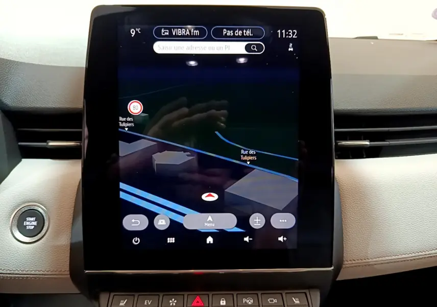 Écran tactile central du tableau de bord de la Renault Clio Initiale Paris orange, avec navigation 3D affichée.