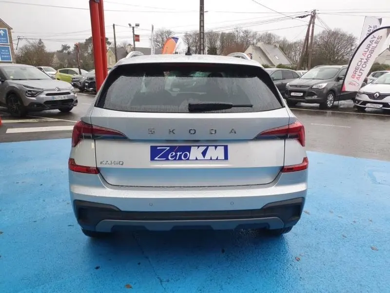 Vue arrière d'un Skoda Kamiq gris diamant métallisé avec feux arrière LED et plaque Zero KM visible.