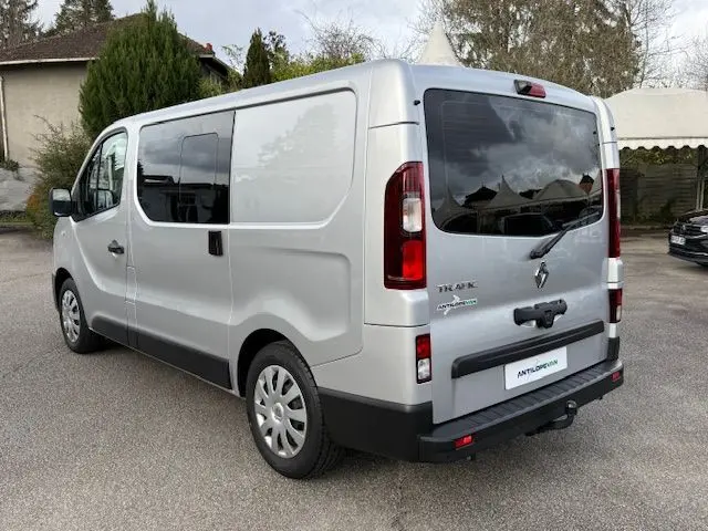 Vue 3/4 arrière droite du Renault Trafic Fourgon gris platine avec hayon vitré et porte latérale coulissante.