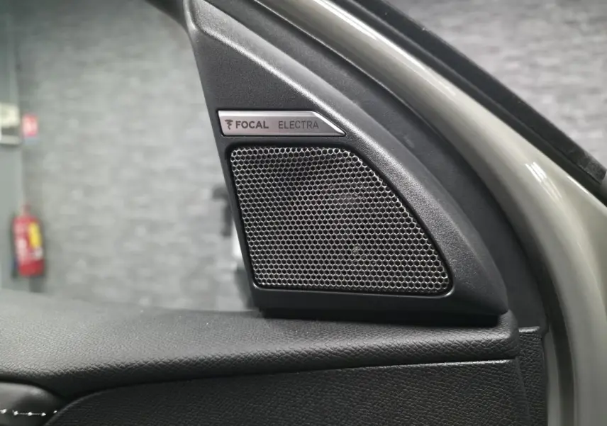 Gros plan sur le haut de la porte avant gauche du DS7 Crossback gris, mettant en valeur l'enceinte FOCAL Electra intégrée.