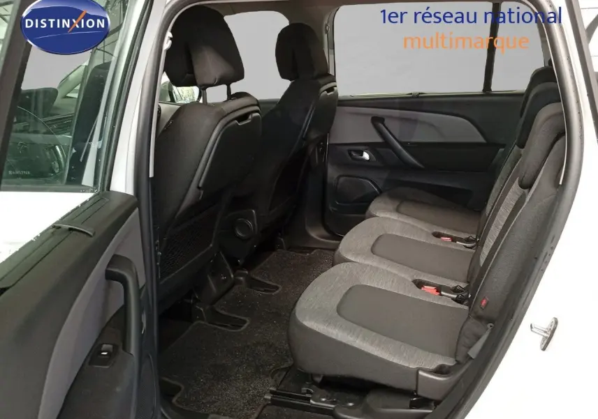 Vue intérieure côté droit sur les sièges arrière gris du Citroën Grand C4 Picasso blanc avec porte ouverte.