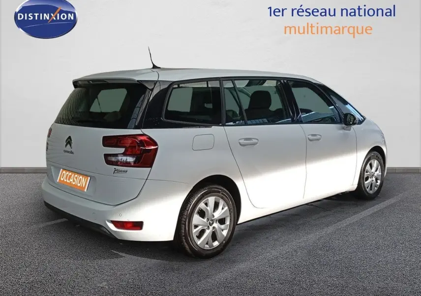 Vue 3/4 arrière droite d'un Citroën Grand C4 Picasso blanc avec vitres teintées et jantes alliage.