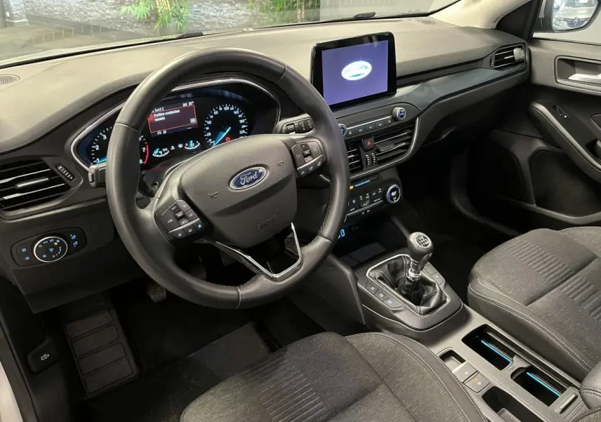 Intérieur avant droit de la Ford Focus gris, volant multifonction, écran tactile et boîte manuelle visible.