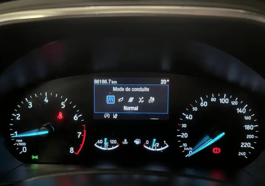 Tableau de bord de Ford Focus gris 2021 montrant l'affichage numérique du mode de conduite et compteurs éclairés.