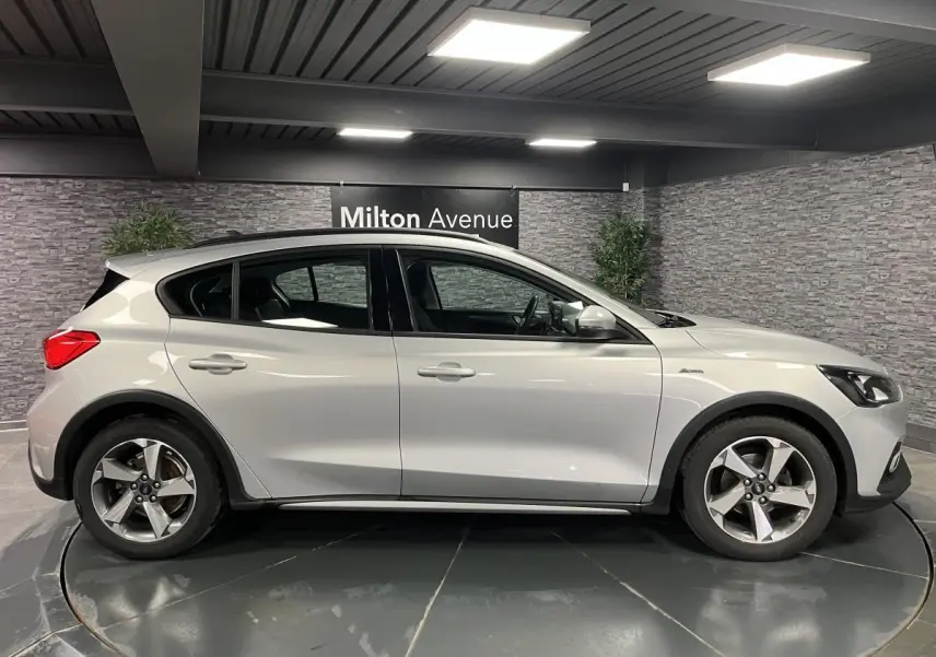 Profil côté gauche d'une Ford Focus gris lunaire 2021 avec jantes alliage 17 pouces et poignées couleur carrosserie.