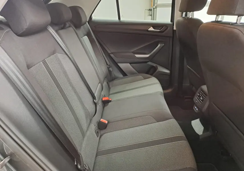 Vue intérieure du siège arrière droit du Volkswagen T-Roc 2024, tissu gris avec ceintures de sécurité visibles.