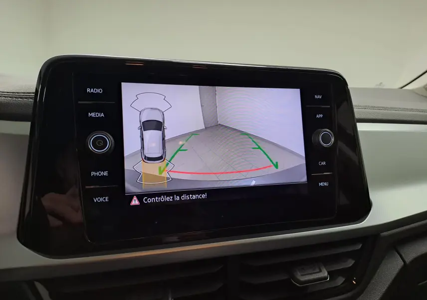 Écran de caméra de recul affichant l'aide au stationnement du Volkswagen T-Roc Gris Indium, vue intérieure du tableau de bord.