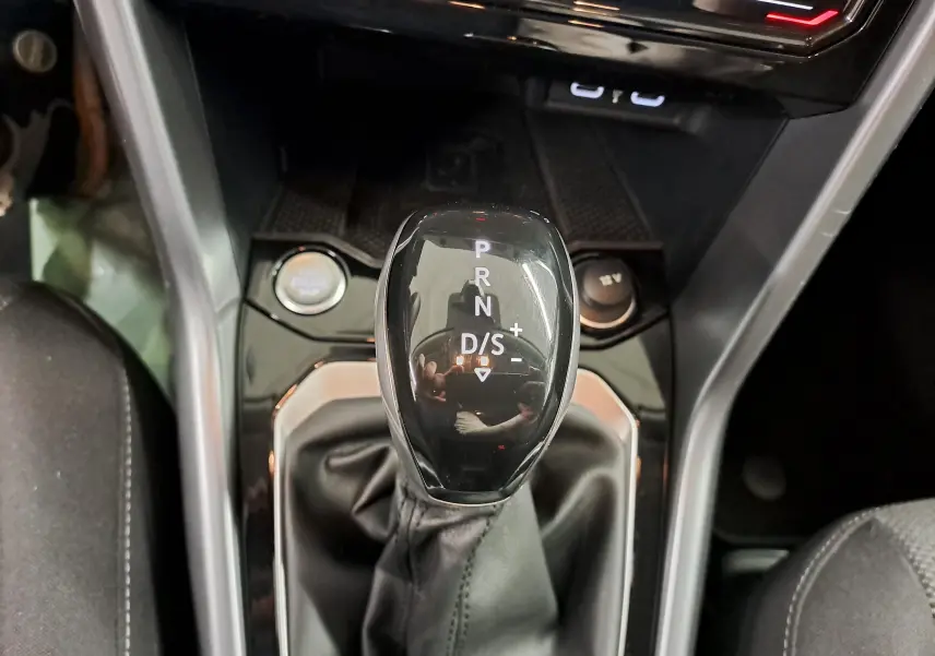 Le levier de vitesse automatique DSG7 du Volkswagen T-Roc 2024, avec mode sport et démarrage sans clé visible.