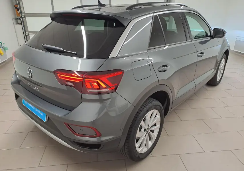 Volkswagen T-Roc 2024 gris Indium en 3/4 arrière droit, avec jantes alliage 17'' Johannesburg et feux allumés.
