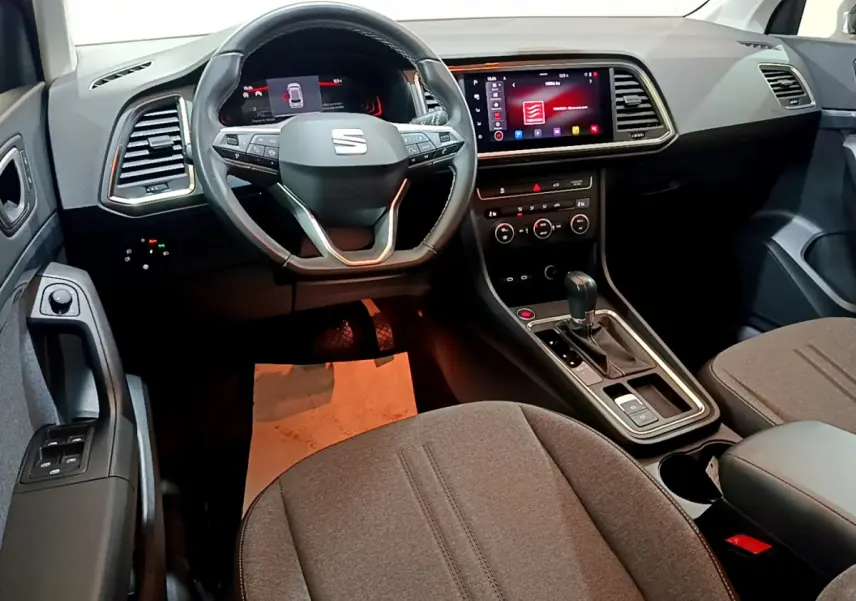 Intérieur du SEAT Ateca 2022 vu côté conducteur, volant cuir, écran tactile central et levier de boîte automatique.