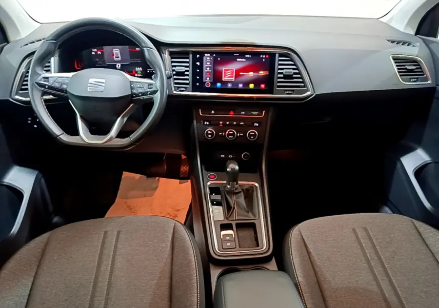 Intérieur de la SEAT Ateca 2022 vu de face, tableau de bord noir avec écran tactile central et volant multifonctions.