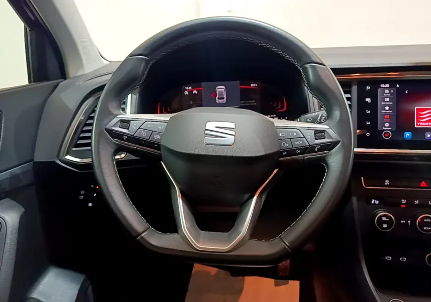 Volant cuir SEAT Ateca 2022 vu de face, avec commandes intégrées et tableau de bord numérique éclairé.
