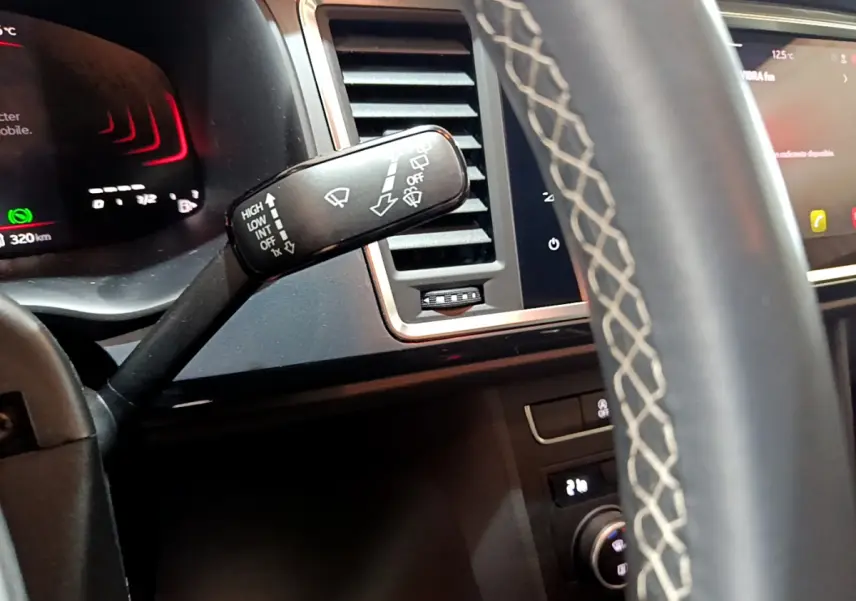 Détail du commodo d'essuie-glace côté gauche dans l'habitacle noir du SEAT Ateca 2022, avec tableau de bord et écran tactile visibles.