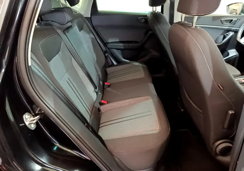 Vue intérieure côté gauche sur la banquette arrière tissu gris et noir du SEAT Ateca noir 2022 avec portes ouvertes.