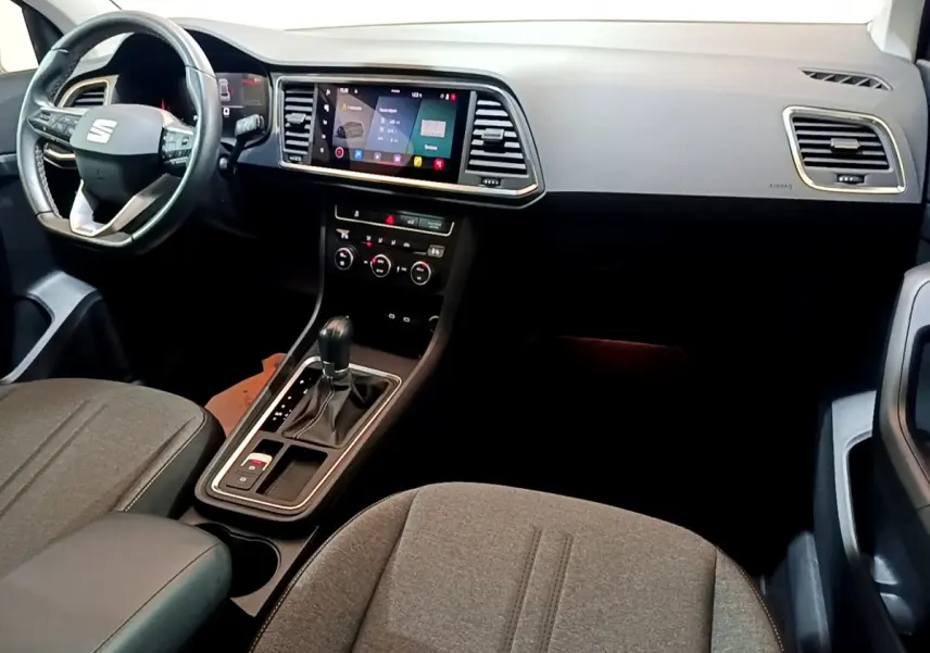 Vue intérieure côté conducteur du tableau de bord et console centrale du SEAT Ateca 2022 avec écran tactile et volant cuir noir.