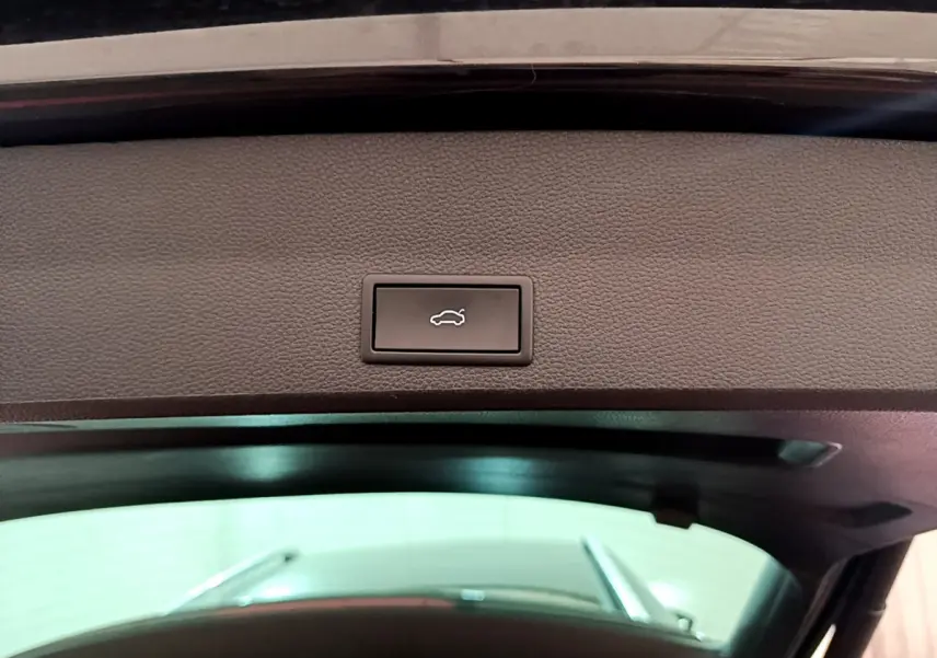 Bouton d'ouverture électrique du coffre vu de l'intérieur du hayon d'un SEAT Ateca noir 2022.