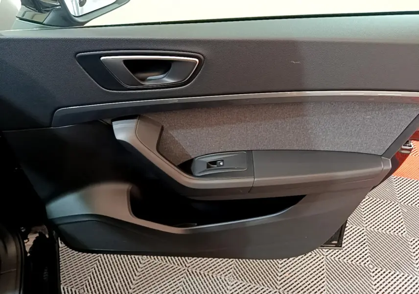 Gros plan sur la garniture intérieure de la porte avant gauche noire du SEAT Ateca 2022, avec insert tissu gris.
