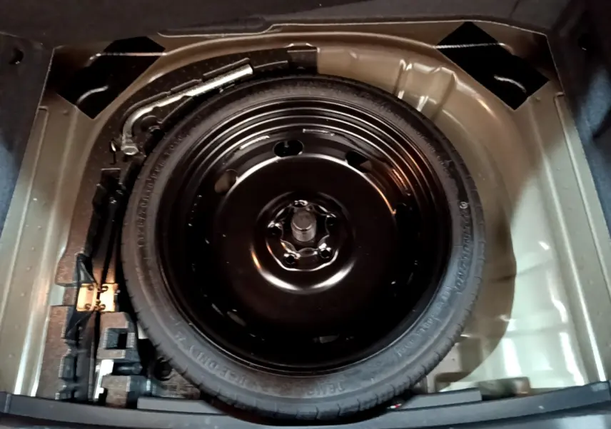 Roue de secours galette noire dans le coffre d'un SEAT Ateca 2.0 TDI 150 DSG7 2022, vue de dessus.