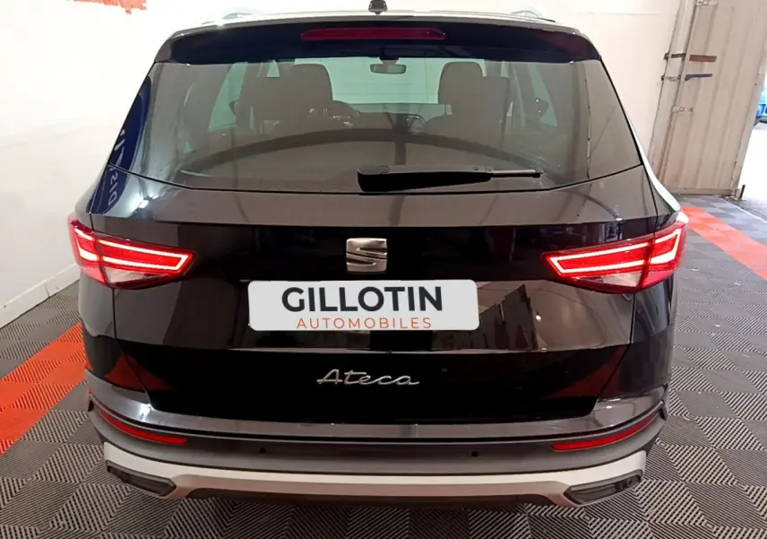 Vue arrière d'un SEAT Ateca noir avec feux LED allumés et logo visible sur un sol à damier rouge et gris.