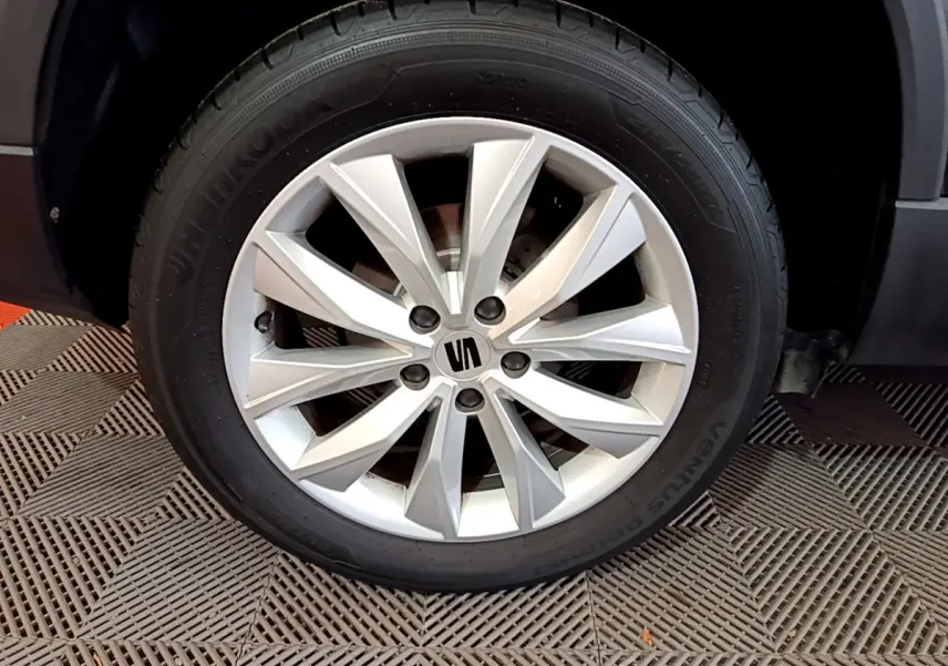 Gros plan sur la roue avant droite du SEAT Ateca noir 2022, mettant en valeur la jante alliage argentée au design moderne.