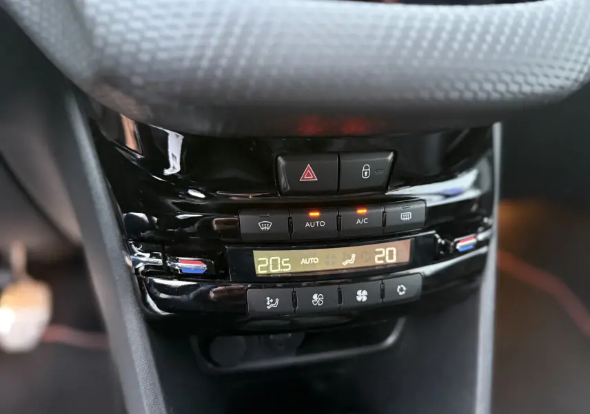 Gros plan sur la console centrale noire du Peugeot 2008 GT Line 2018, montrant les commandes de climatisation digitale.