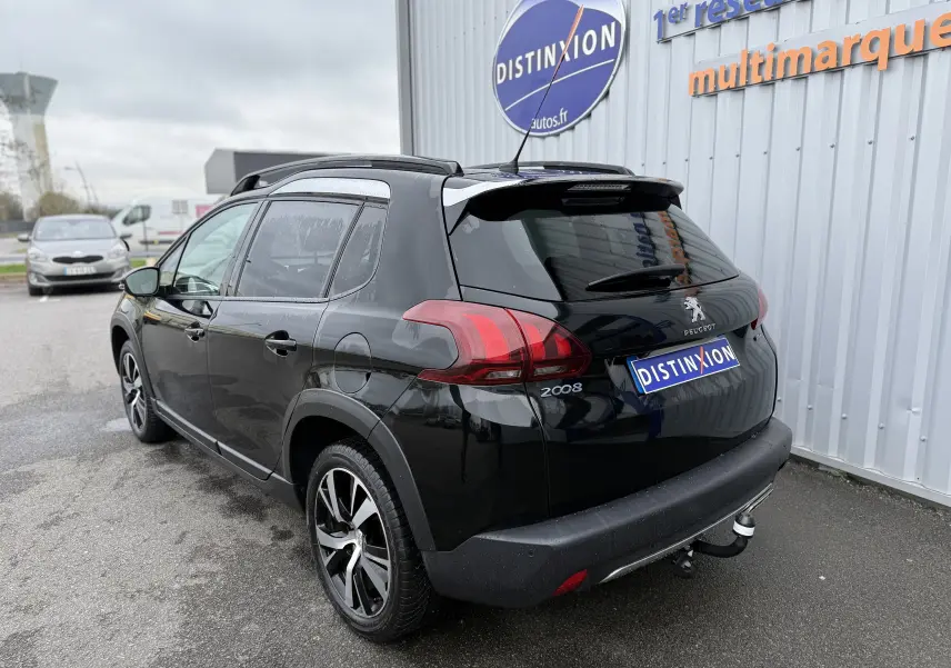 Peugeot 2008 noir 2018 vue 3/4 arrière droit, avec jantes alliage et attelage de remorque visible.