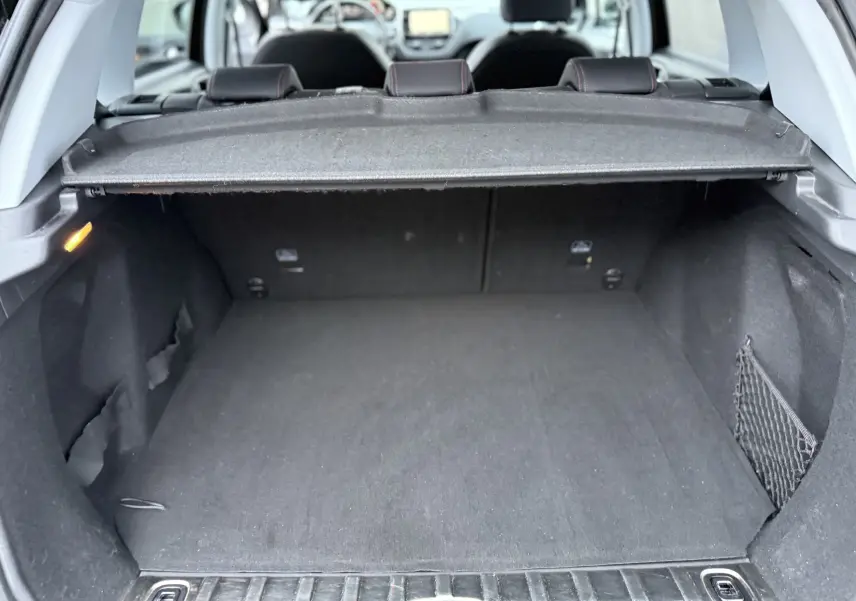 Coffre ouvert vu de l'arrière d'un Peugeot 2008 noir 2018, montrant l'espace de chargement et la tablette cache-bagages.