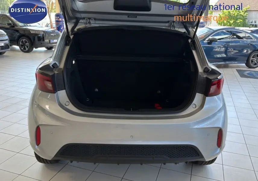 Vue arrière d'une MG3 1.5L Hybrid+ 195CH Luxury en Cosmic Silver Metal avec coffre ouvert dans un showroom.