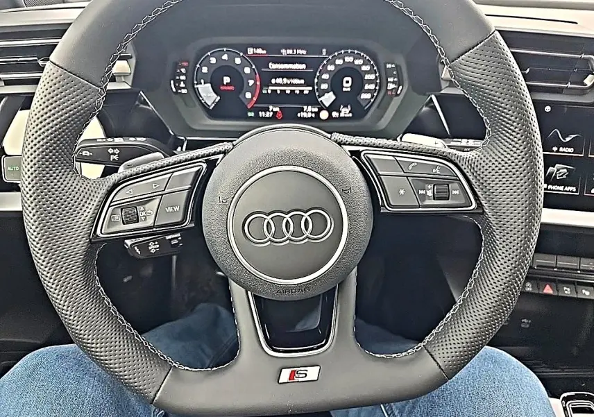 Vue rapprochée du volant sport en cuir noir avec logo S et tableau de bord digital d'une Audi A3 Sportback 2026.