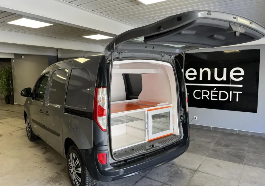 Vue 3/4 arrière gauche d'un Renault Kangoo Express gris foncé avec hayon arrière ouvert montrant l'espace de chargement aménagé.