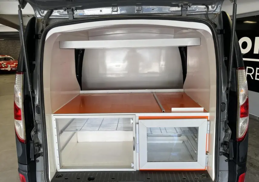 Vue arrière du Renault Kangoo Express gris foncé avec aménagement intérieur de rangement vitré et compartiment orange.