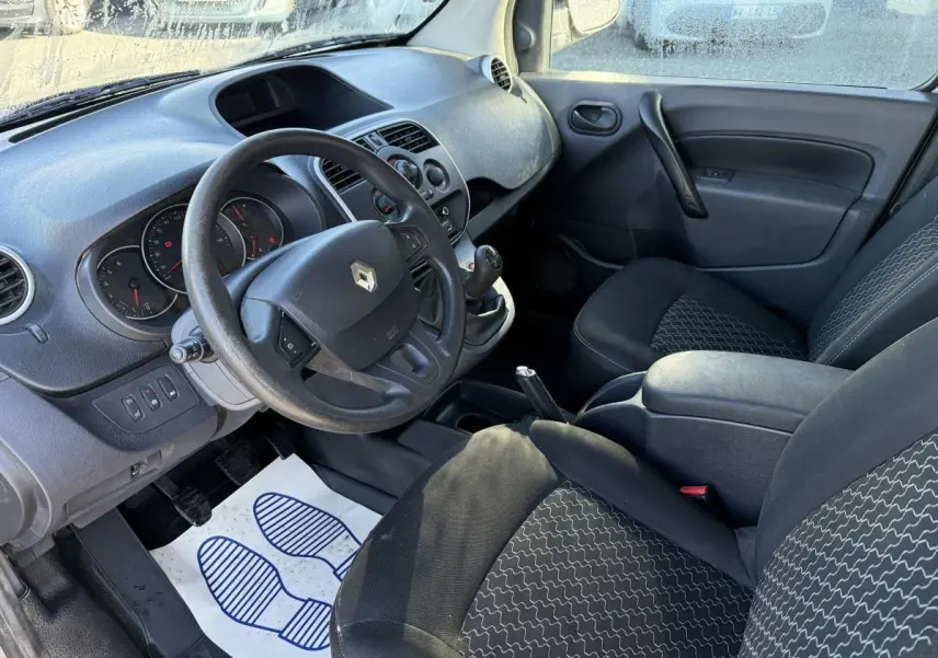 Intérieur avant du Renault Kangoo Express 2016, vue côté conducteur, sièges noirs et tableau de bord gris foncé.