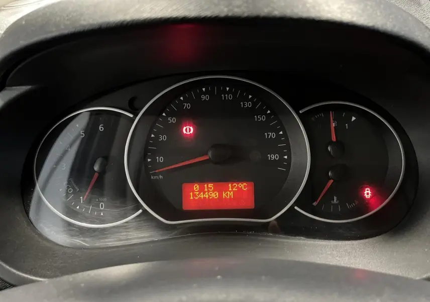 Vue rapprochée du tableau de bord noir du Renault Kangoo Express gris foncé, affichant 134490 km et témoins allumés.