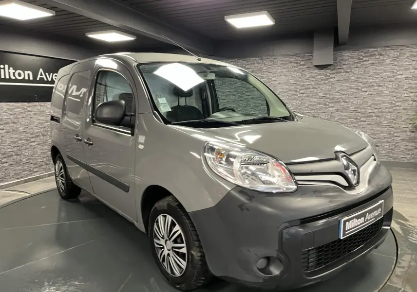 Renault Kangoo Express gris foncé en 3/4 avant droit, avec boucliers noirs et jantes à enjoliveurs pleins.