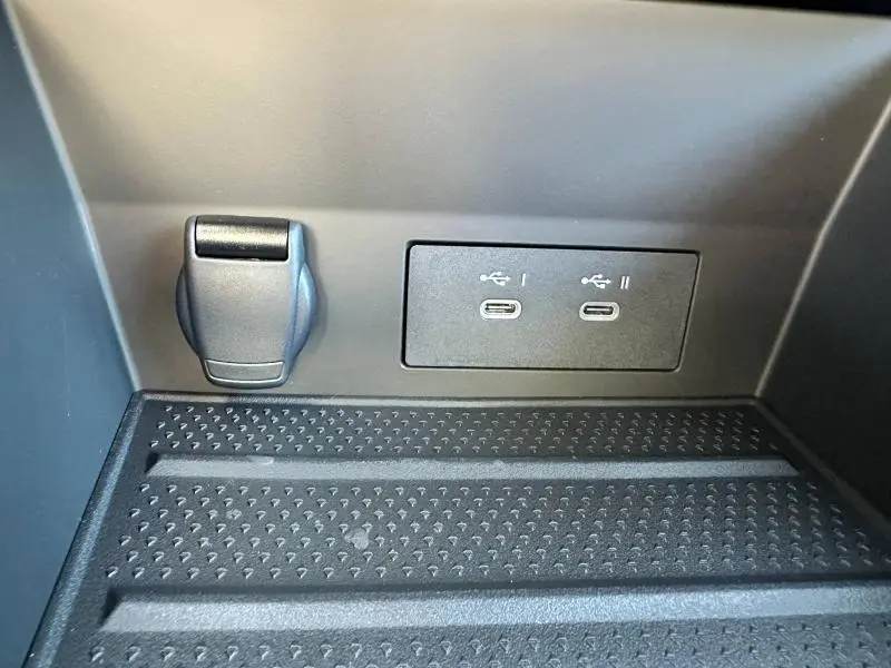 Prise 12V et deux ports USB-C noirs dans le compartiment avant du Renault Captur 2025 esprit Alpine rouge flamme.