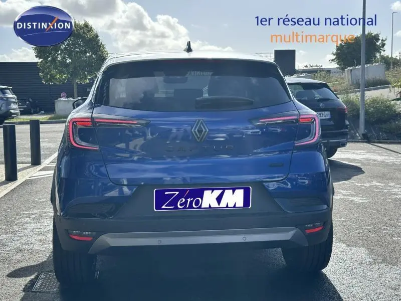 Vue arrière d'un Renault Captur 1.6 E-Tech hybride bleu avec feux LED et logo Renault bien visibles.