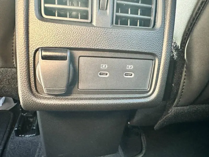 Prise USB double et prise 12V noire au bas de la console centrale arrière du Renault Captur Rouge Flamme 2025.