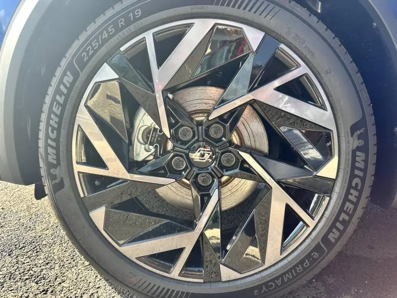 Gros plan sur la jante alu noire et argentée du Renault Captur 2025 avec pneu Michelin visible sur sol asphalté.