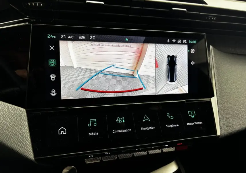 Écran tactile central de la Peugeot 308 gris clair montrant la caméra de recul et l'aide au stationnement arrière.