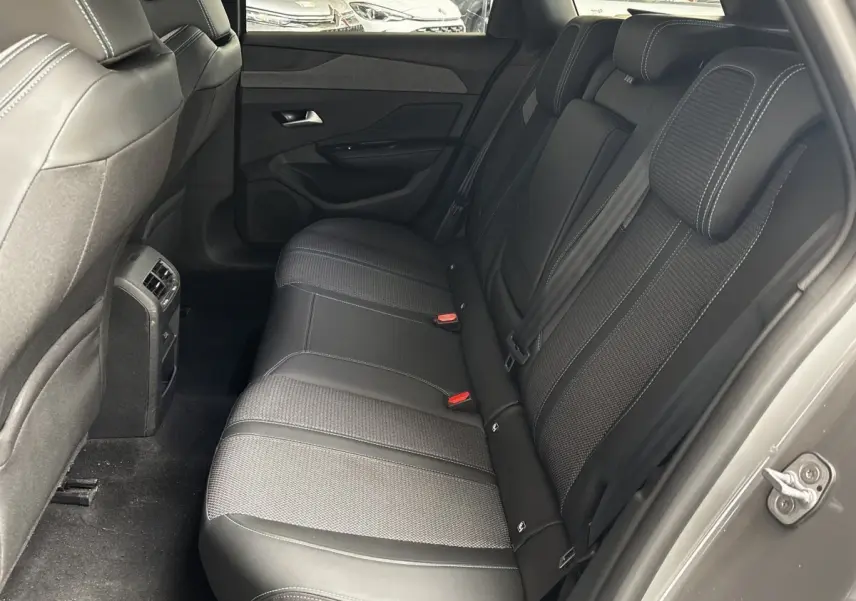 Vue intérieure côté droit montrant la banquette arrière noire et les finitions tissu et cuir de la Peugeot 308 gris clair.