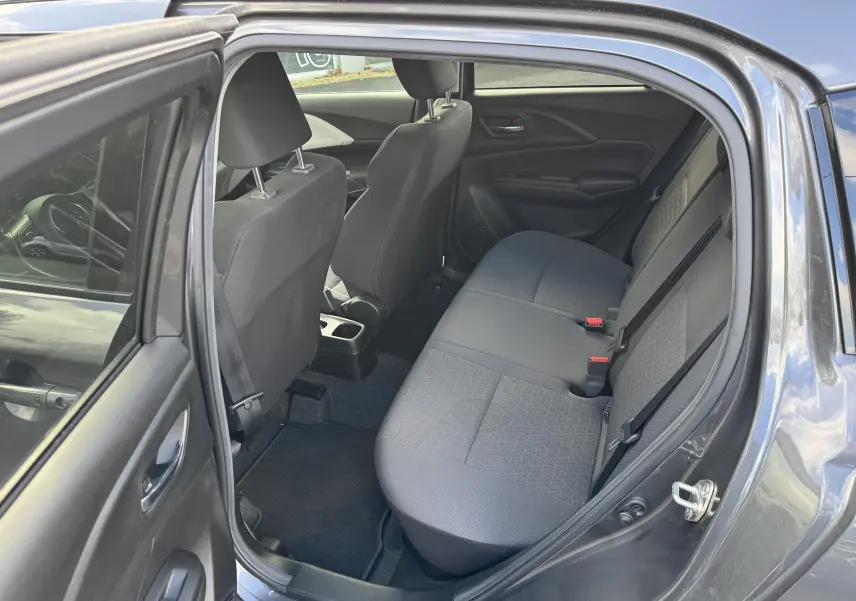 Vue intérieure côté gauche sur la banquette arrière grise de la Suzuki Swift 1.2 Hybrid Privilège 2025 avec porte ouverte.