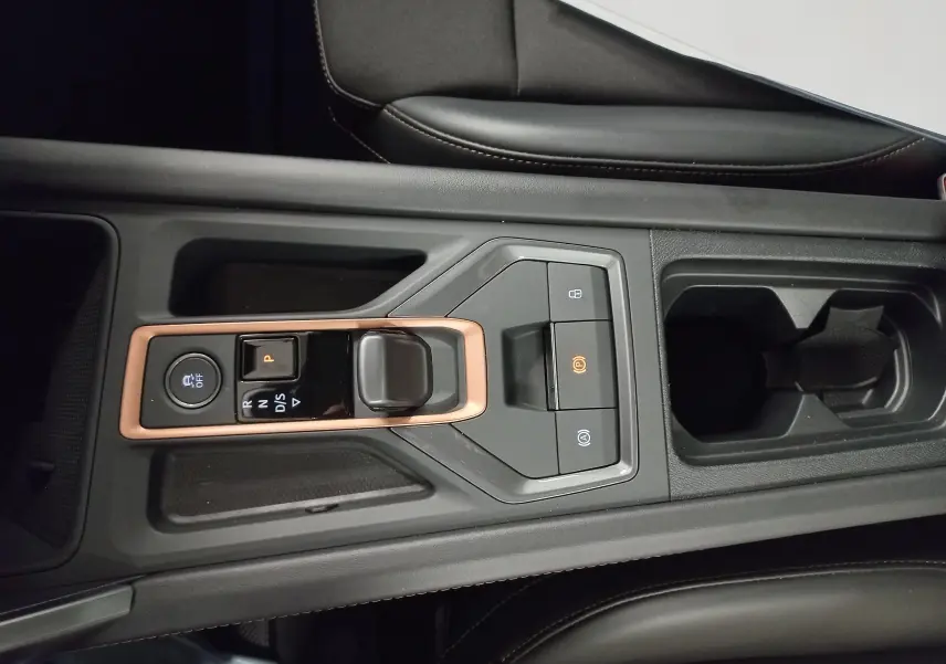 Vue rapprochée de la console centrale noire avec levier de vitesses automatique et surpiqûres cuivrées du CUPRA Formentor 2025.