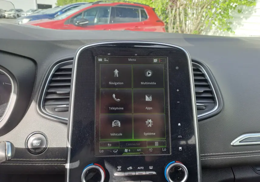 Vue intérieure du tableau de bord du Renault Scenic IV 2018, avec écran tactile central et commandes de climatisation visibles.